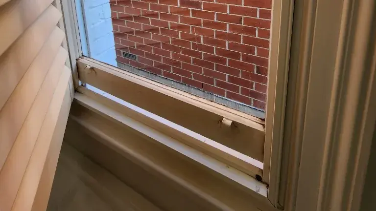 Gap under a timber sash window in a Tasmanian home, a typical draught path around worn frame junctions.